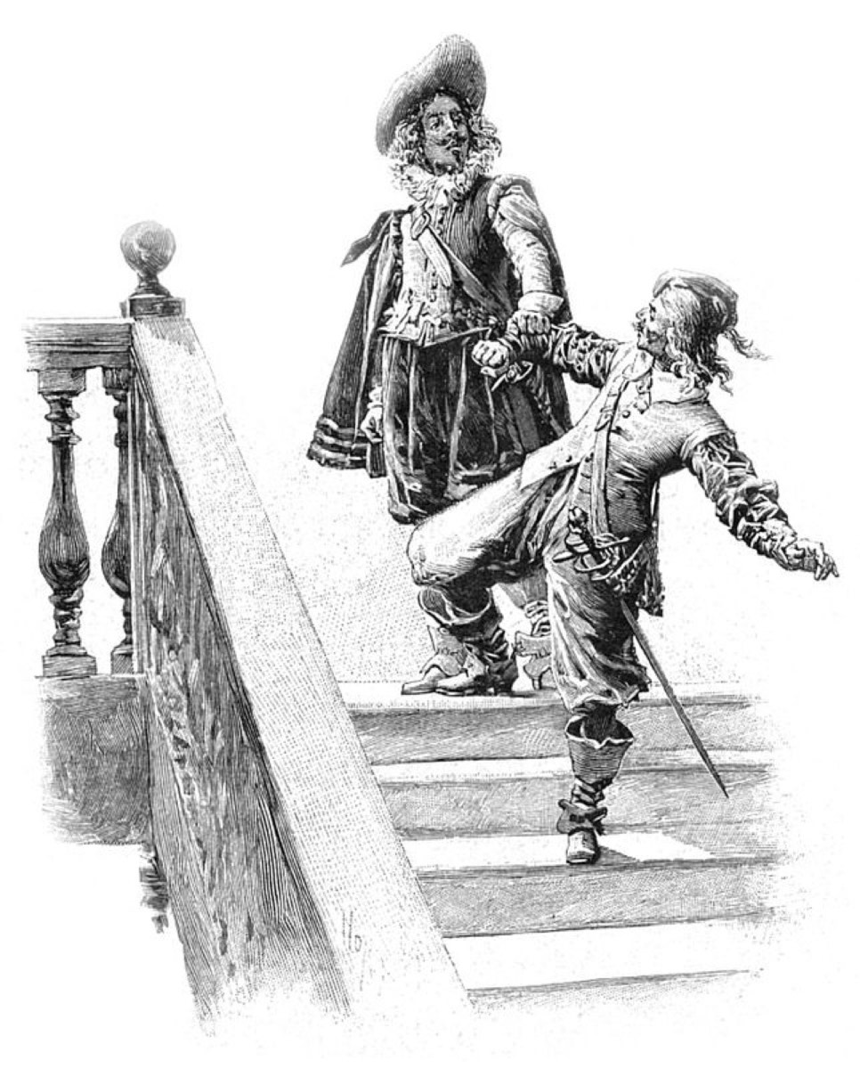 Na escadaria de Tréville, d’Artagnan esbarra em Athos, que leva a mão ao ombro ferido.